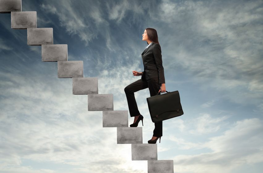  businesswoman stepping up a staircase with sky in the background